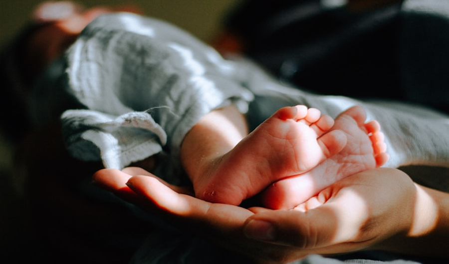 Parent holding newborn baby's feet